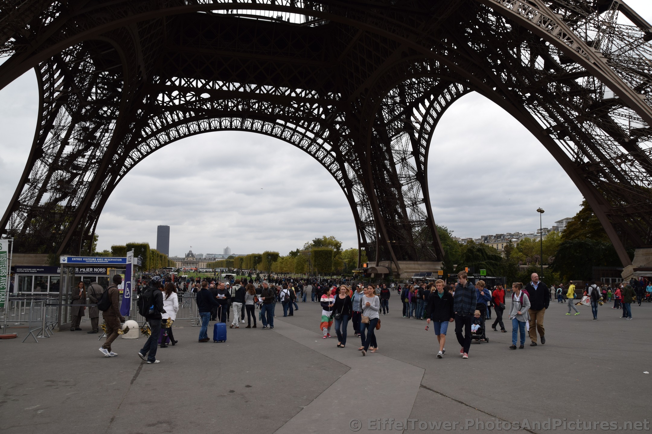 Tourists walking under the Eiffel Tower.jpg