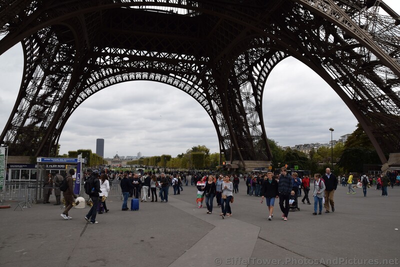 Tourists walking under the Eiffel Tower.jpg